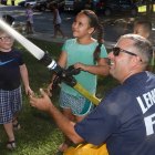 A Lemoore volunteer firefighter shows off one of the department's fie hoses.